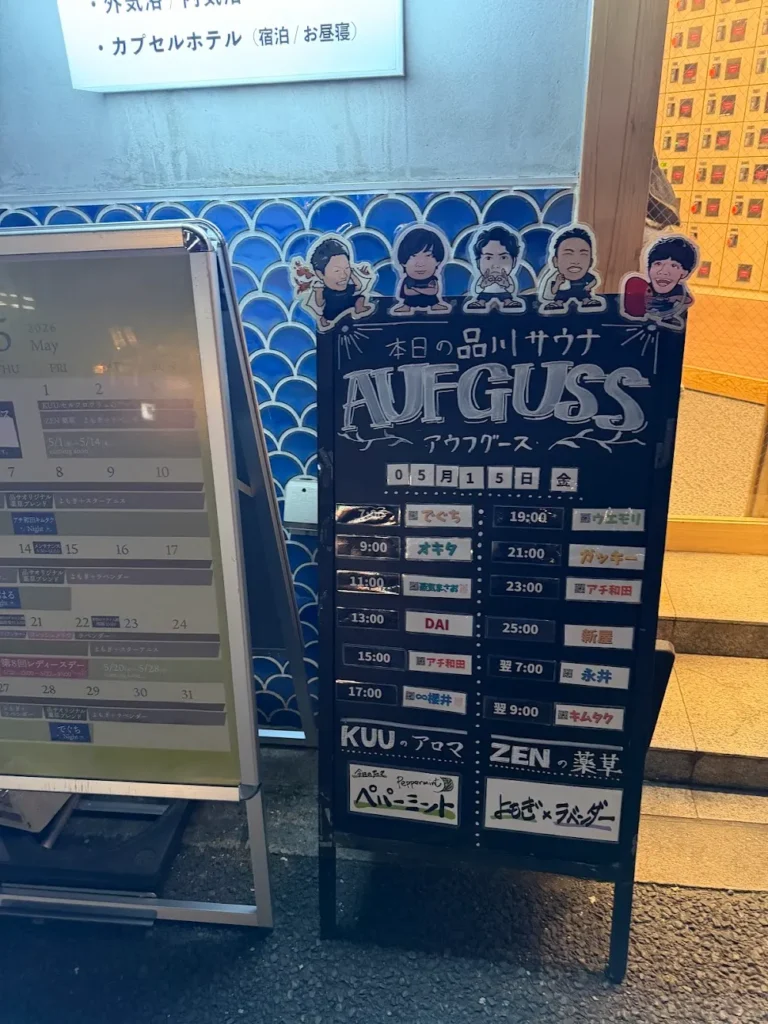 品川サウナ入口に設置されたアウフグーススケジュール看板。黒板に「本日の品川サウナ AUFGUSS」と題し、時間帯ごとの熱波師名が一覧表示されている。下部にはKUU（アロマ：ペパーミント）とZEN（薬草）の当日の香りが記載されている