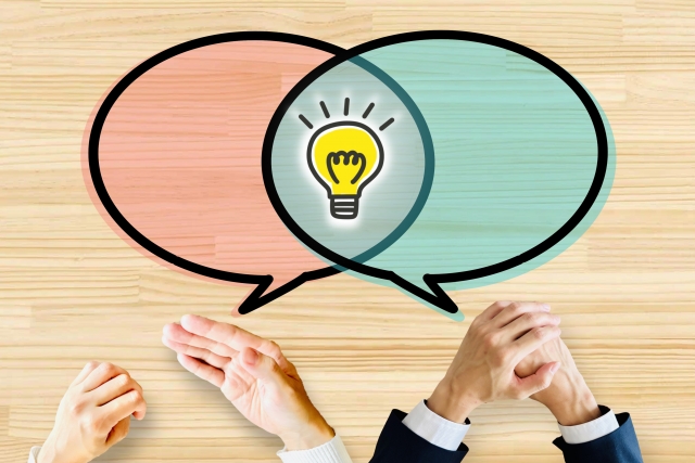 会話する2人の手と吹き出しのイラスト。よくある質問セクションのイメージ画像