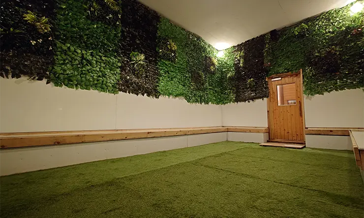 ととのいの郷 秦野湯花楽2F着衣サウナのクールルーム。壁面緑化と人工芝が敷かれた内気浴スペース