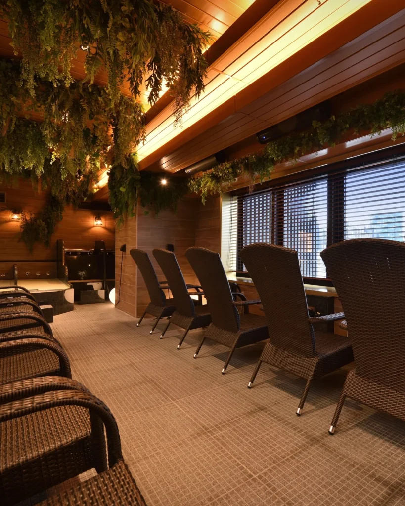 サウナメッツァ大井町トラックスのととのいチェアが並ぶ休憩スペース。椅子のすぐ横に流し用シャワーが設置されている