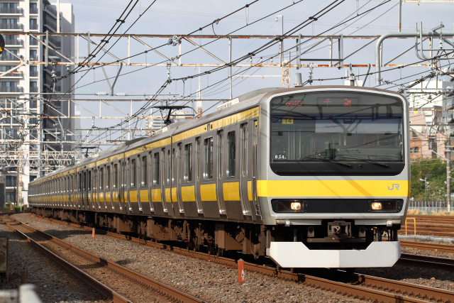JR総武線の黄色い車両（E231系）が走行している様子。行先は「千葉」行き