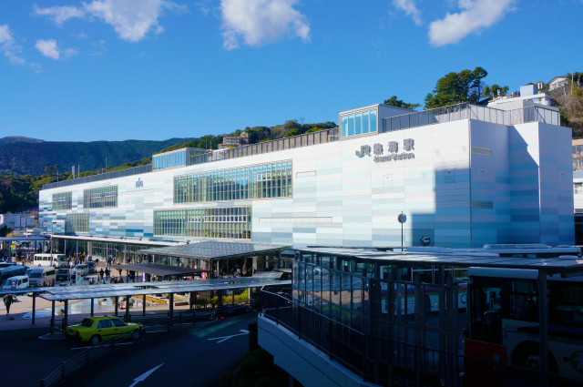 熱海駅の駅舎。白い近代的な建物に「熱海駅」の表示がある外観
