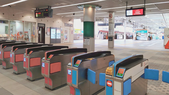 タッチ決済用の読取部が付いた改札機が並ぶ駅構内