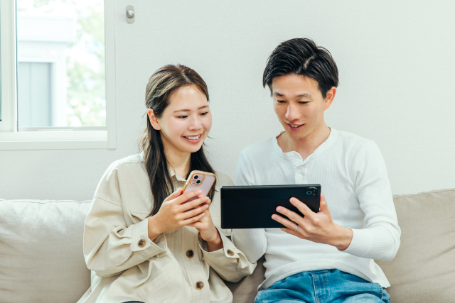 スマートフォンとタブレットでサマーランドの有料席を検討するカップル