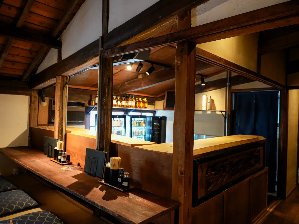 古民家の梁と木製カウンターが見えるKIWAMI SAUNA本店2階の食堂きわみ
