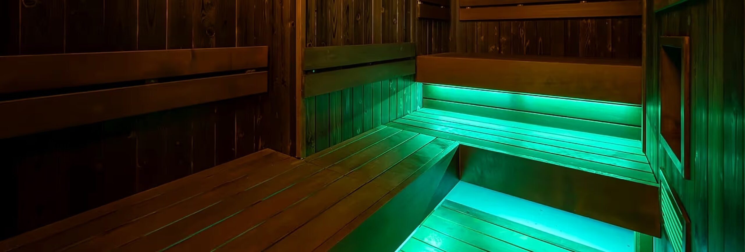 緑色の照明で照らされたLEDiAN SPA 恵比寿店のサウナ室