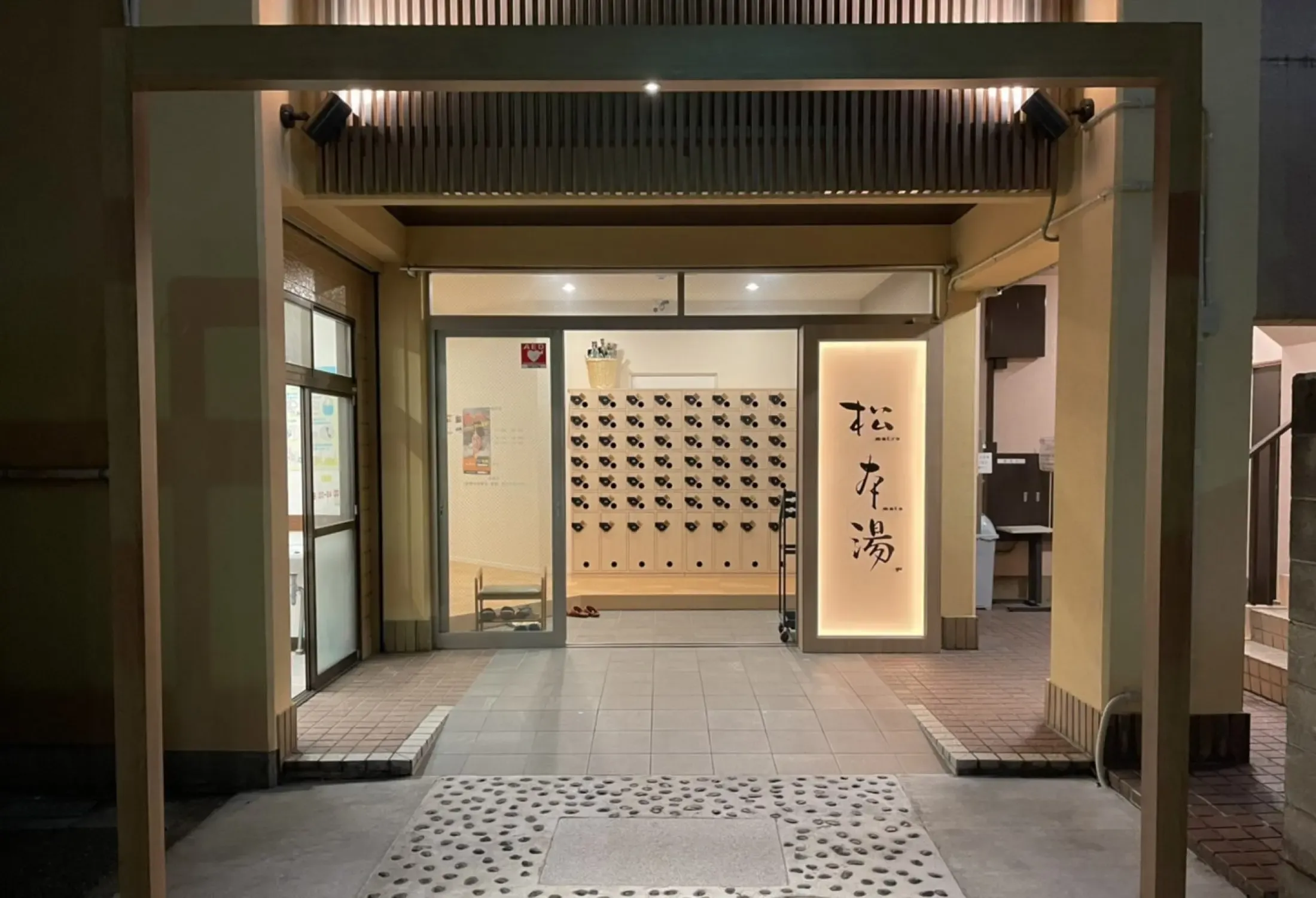 夜にライトアップされた松本湯の入口