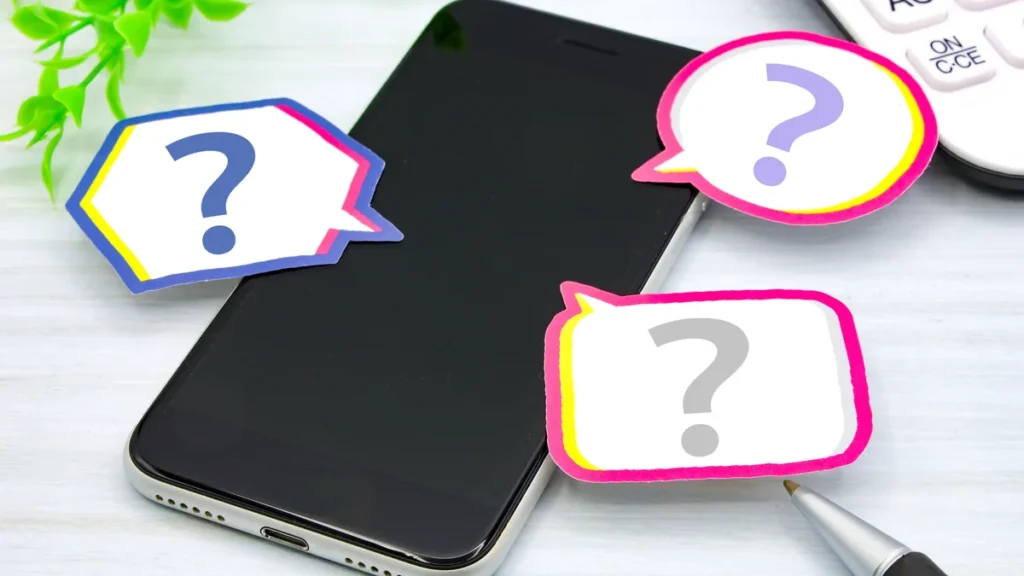 スマートフォンの周りに並ぶ疑問符