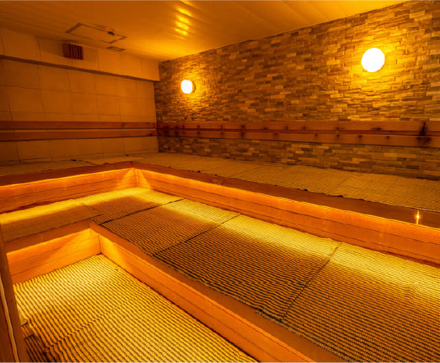 石壁と段状ベンチがあるRAKU SPA BAY 横浜のドライサウナ室