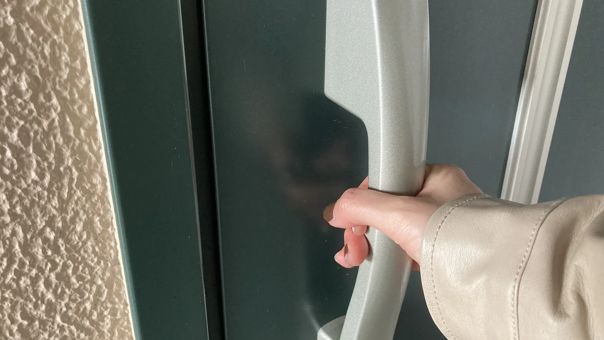 玄関ドアの施錠を確かめる手元