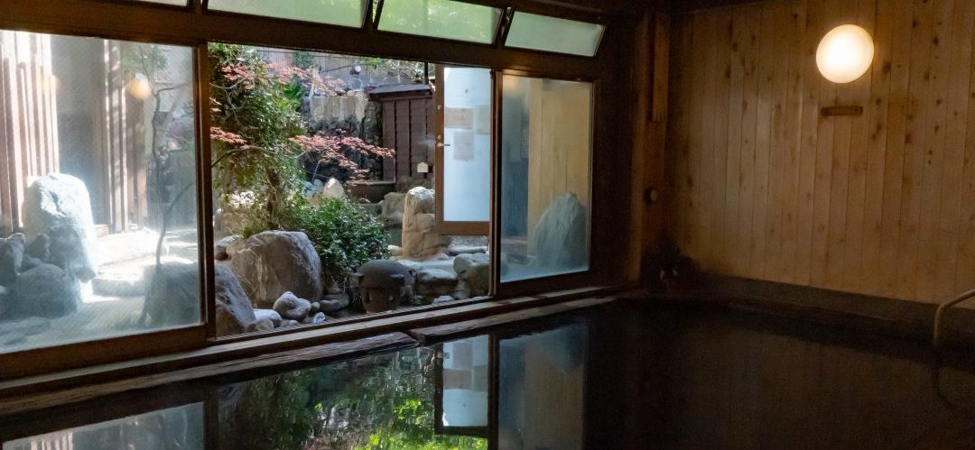 深大寺天然温泉 湯守の里の内湯 窓越しに庭を望む深大寺天然温泉 湯守の里の黒湯内風呂