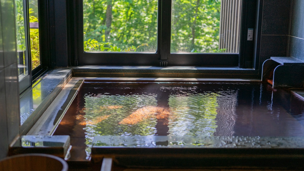 森林を望む高級温泉旅館の半露天風呂のイメージ